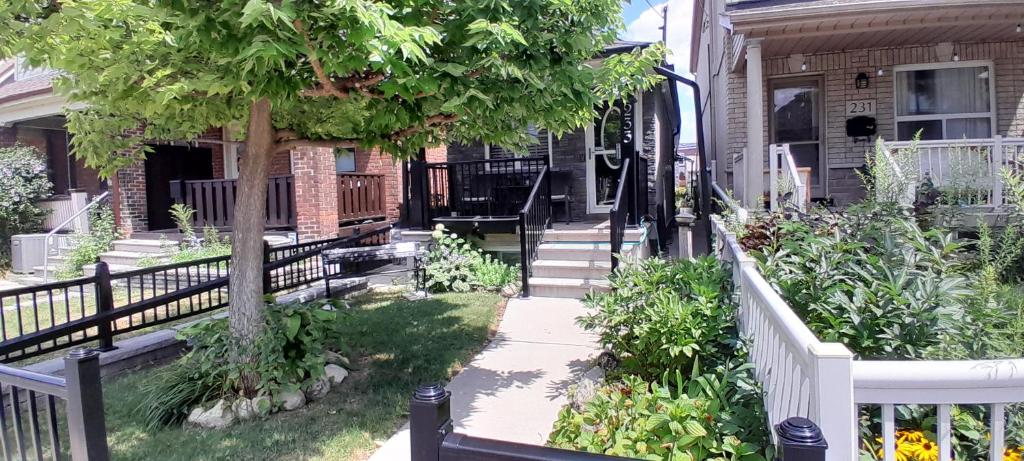 a porch of a house with a white fence at The Cozy Bungalow in North York Nest in Toronto