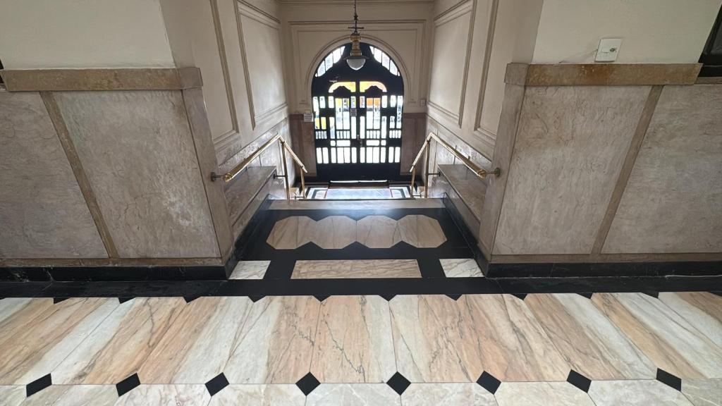 an empty hallway with a gate and wooden floors at Quarto de Hóspedes a 3 min da praia in Rio de Janeiro
