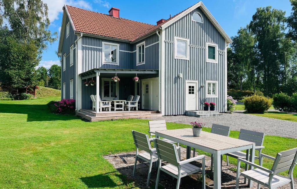 a house with a table and chairs in the yard at 1 Bedroom Awesome Apartment In Värnamo in Förhult
