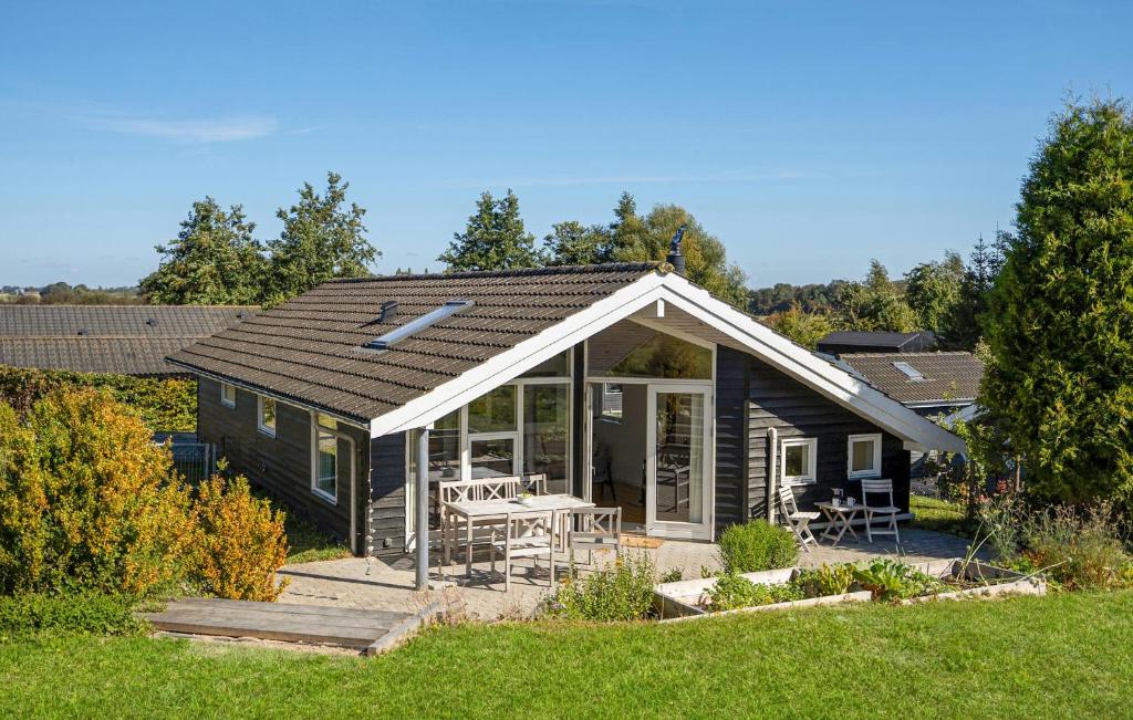 a small house with a porch and a table at Beautiful Home In Rude With Kitchen in Rude