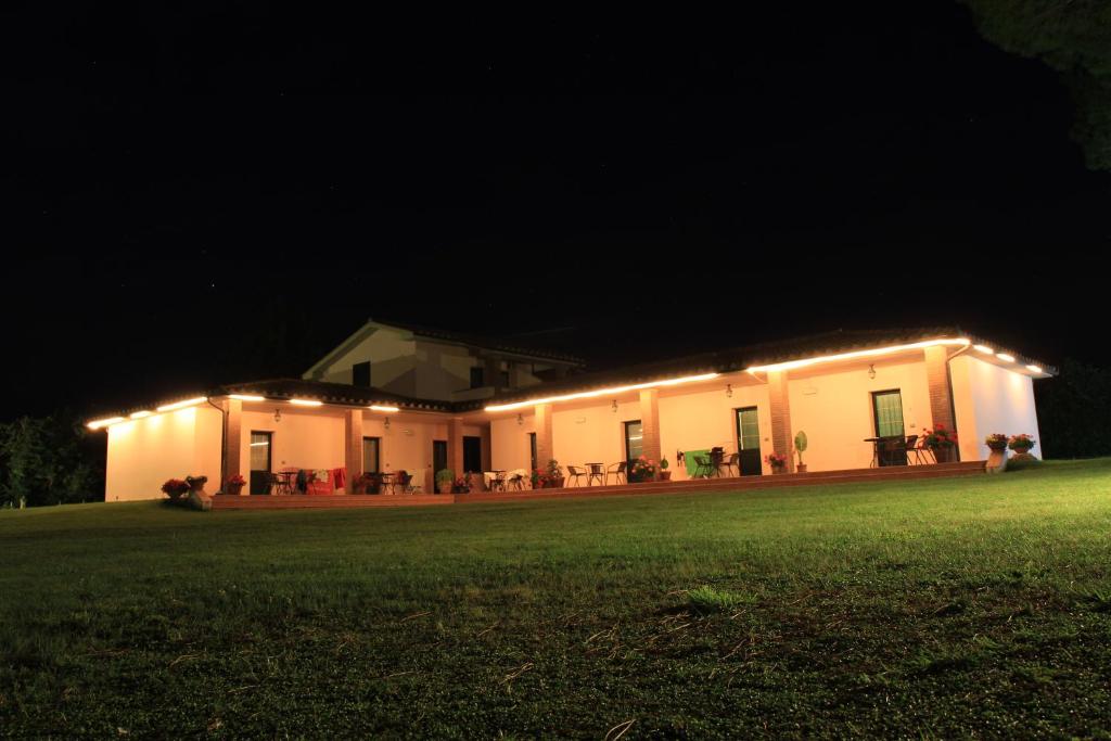 un bâtiment avec des lumières allumées la nuit dans l'établissement Agriturismo Valle Martina, à Saturnia