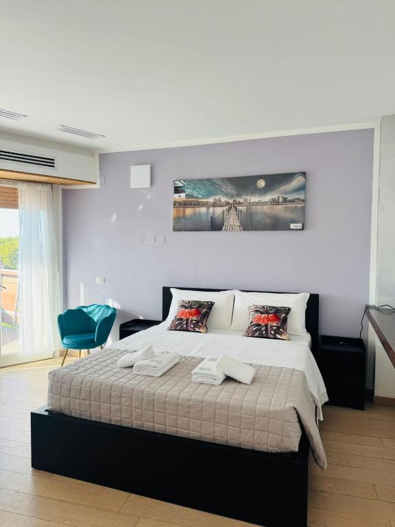a bedroom with a large bed and a blue chair at MMM HOME Train Station 4 in Mestre