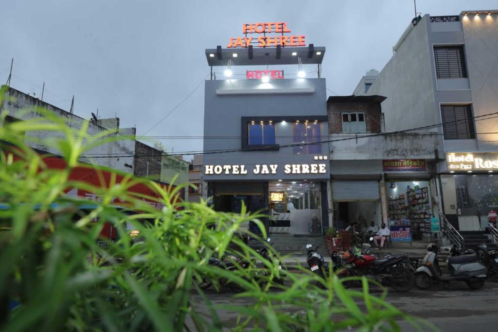 a building with a hotel lay street with motorcycles in front at Hotel Jay Shree in Ujjain