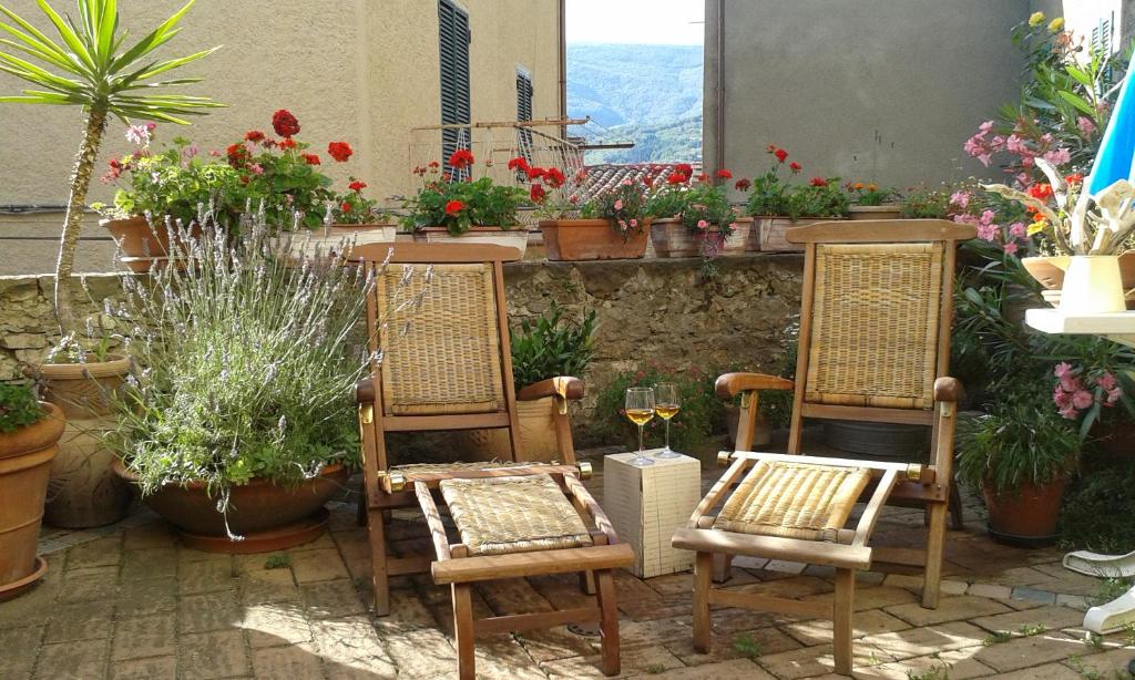 eine Gruppe von Stühlen und Topfpflanzen auf einer Terrasse in der Unterkunft Dimora Toscana in Seggiano
