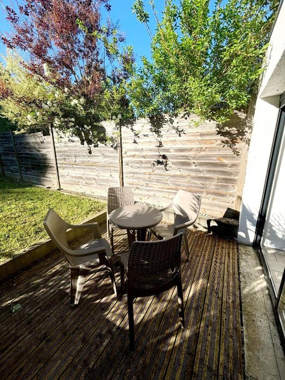 a patio with chairs and a table on a deck at Le coin nature in Amnéville