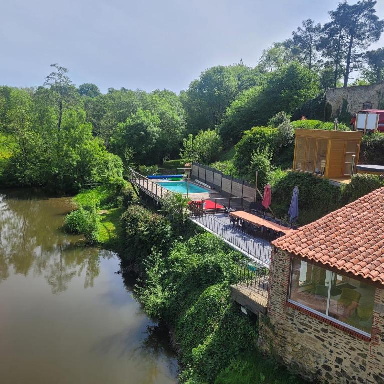 a house with a swimming pool next to a river at Le Moulin du Gué en Vendée Gite de 8 chambres atypique et exceptionnel au bord de l'eau à 30 minutes du PuyduFou agrémenté d'un Sauna et Bain Nordique au feu de bois pour vous détendre entre Amis et Famille in Sainte-Cécile