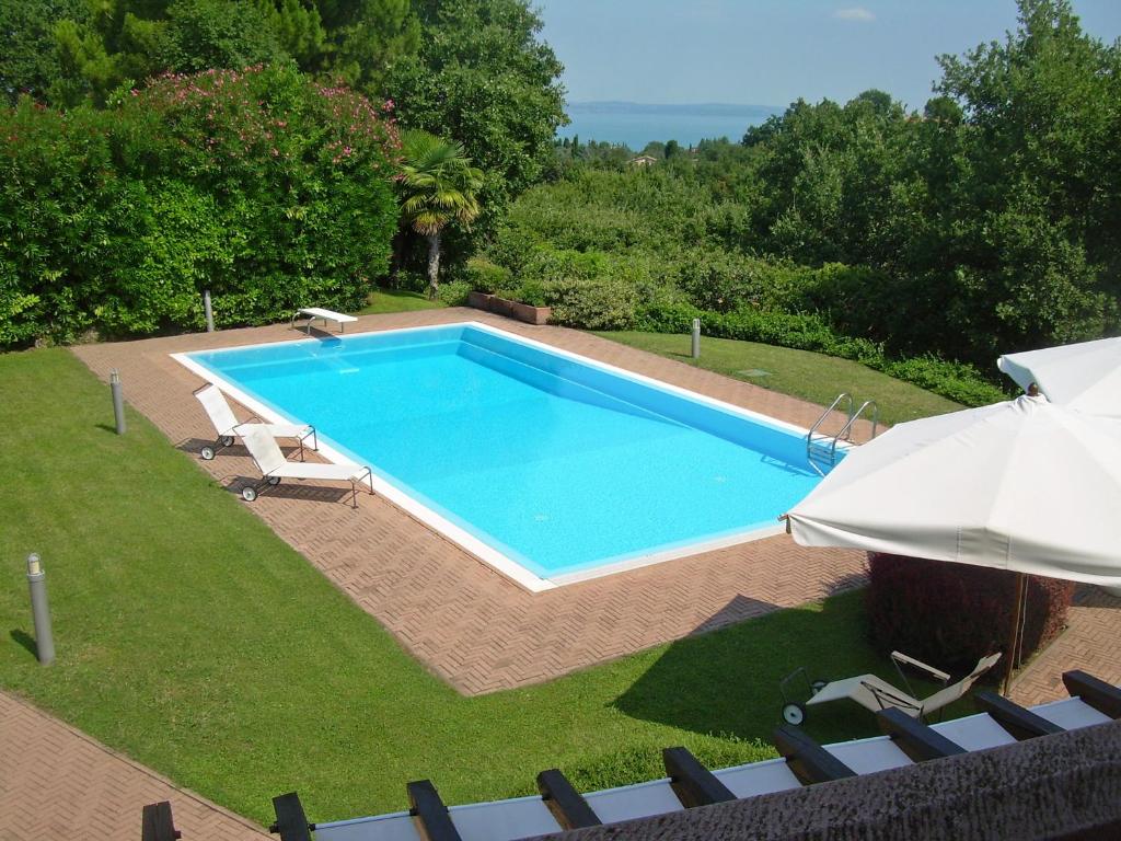 ソイアーノ・デル・ラーゴにあるVilla dei Salici con piscina by Wonderful Italyのスイミングプール(椅子、パラソル付)の景色を望めます。