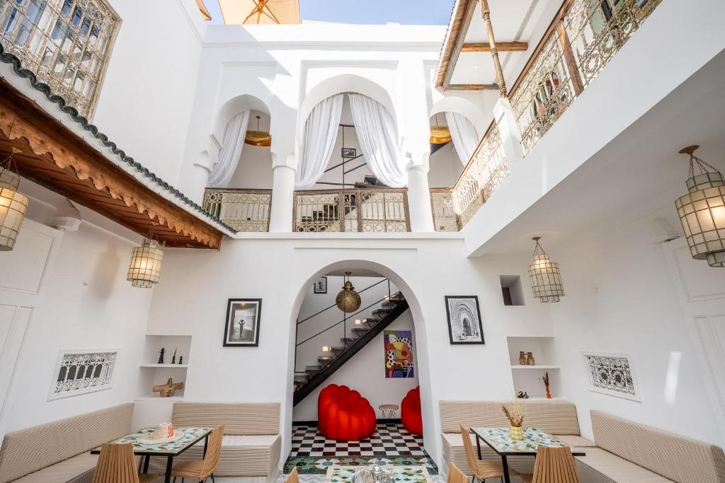 a restaurant with tables and chairs and a staircase at Riad LILIA in Marrakech