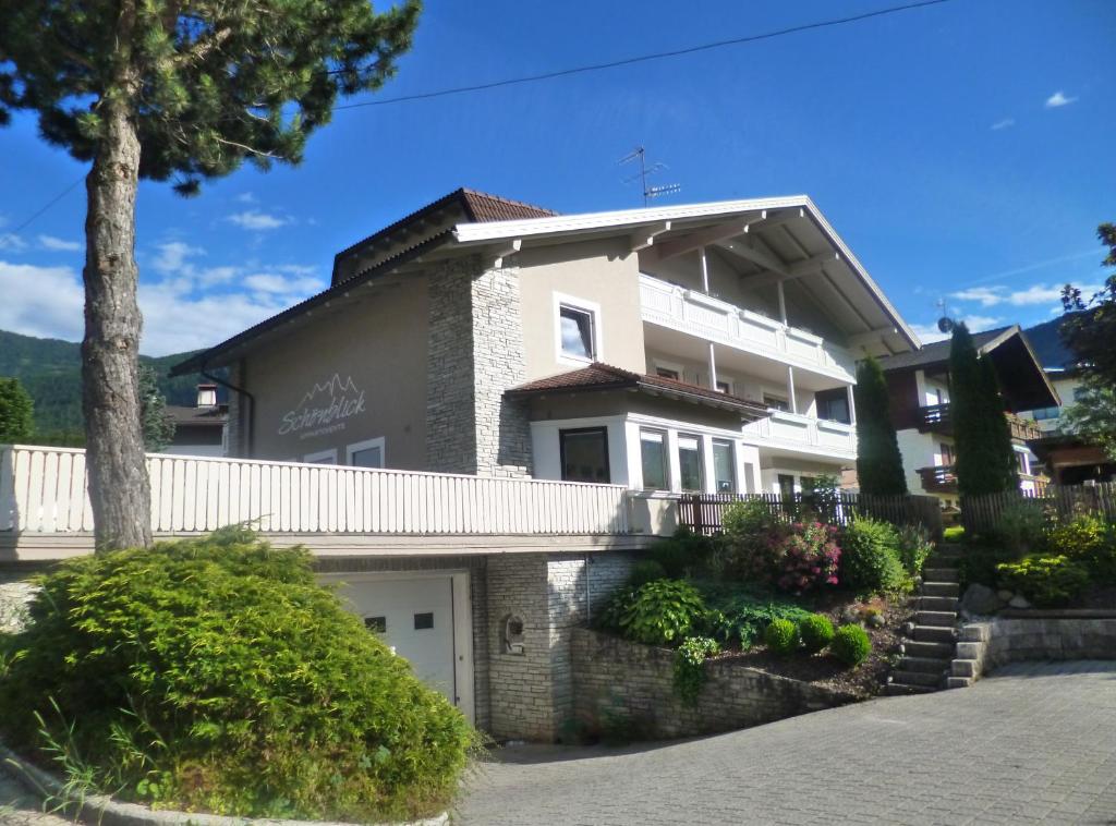 une grande maison blanche avec un garage blanc dans l'établissement Haus Schönblick, à San Lorenzo di Sebato
