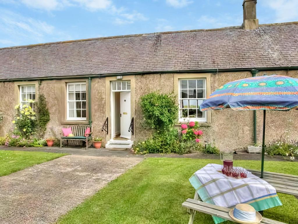 a house with a table and an umbrella in the yard at Thelma's House - Uk48886 in Belford
