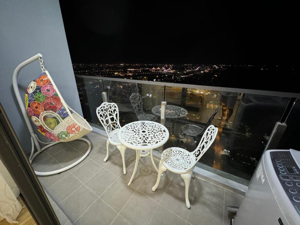 three chairs and a table on a balcony with a view at Cosy and chic Cando - vue sur le fleuve Mékong in Phnom Penh