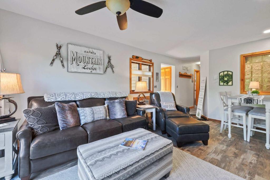 un soggiorno con un divano e un ventilatore a soffitto di New Tee & Ski Getaway Schuss Golf Ski Villa a Mancelona