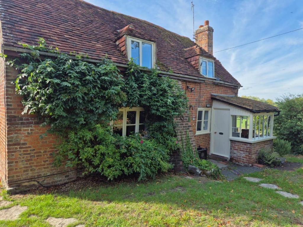 ein Backsteinhaus mit Efeu nebenbei in der Unterkunft Manor Cottage in Downton