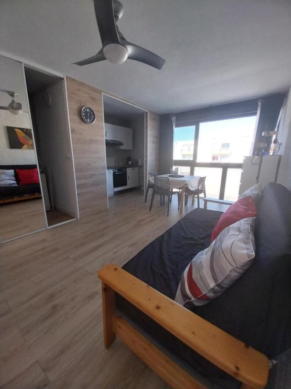 Cet appartement comprend une chambre avec un lit et un salon avec une table. dans l'établissement Appartement T2 lumineux à 200m de la plage, tout équipé, à Port-la-Nouvelle