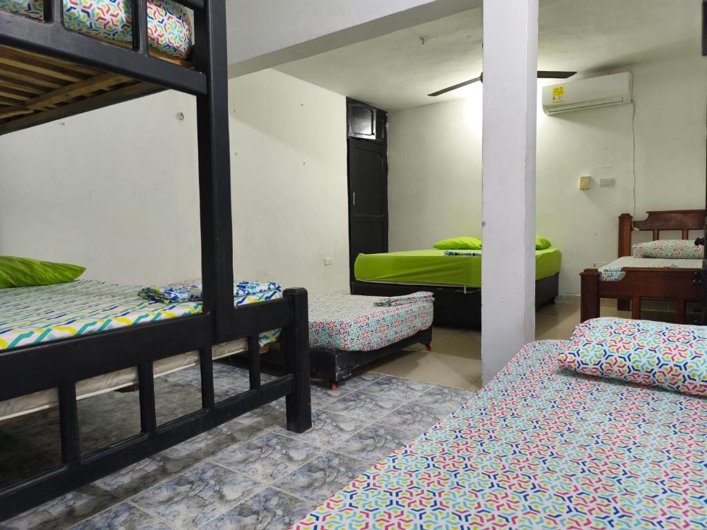 a room with three bunk beds and a table at Las Margaritas Frente al Mar 1 in Coveñas