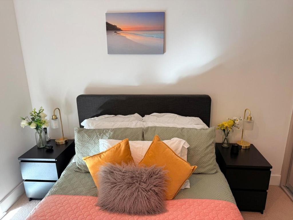 a bedroom with a bed with pillows and two night stands at Exquisite Spacious 1 Bedroom Apartment-Colindale in Colindale