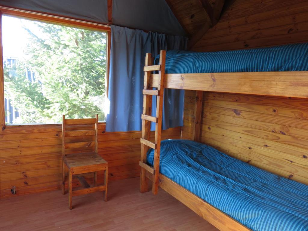 a bunk bed and a chair in a cabin at Ubuntu in Villa La Angostura