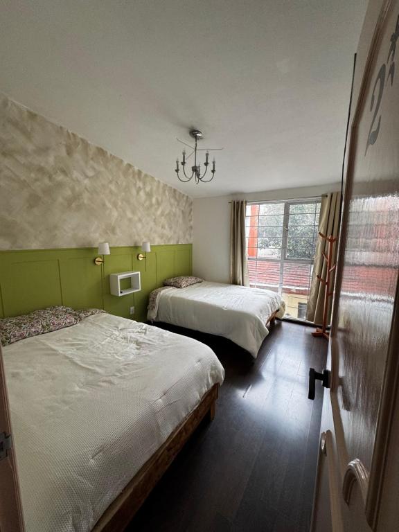 a bedroom with two beds and a chandelier at Casa Pascal in Toluca