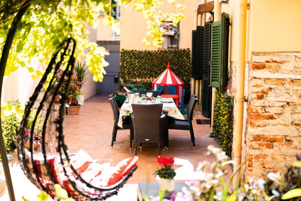 eine Terrasse mit einem Tisch mit Stühlen und einem roten Regenschirm in der Unterkunft Santa Croce Garden Apartment in Florenz