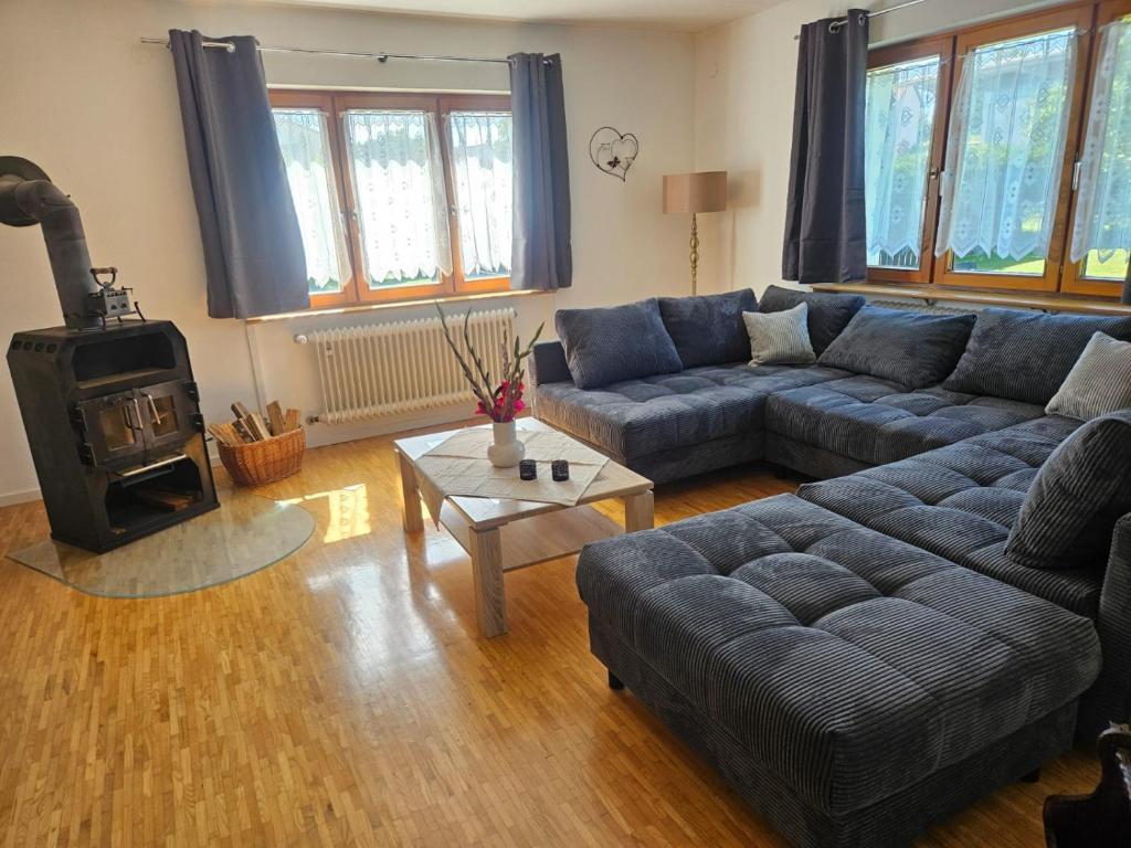 ein Wohnzimmer mit einem Sofa und einem Holzofen in der Unterkunft Ferienhaus am Gupfen in Weilheim