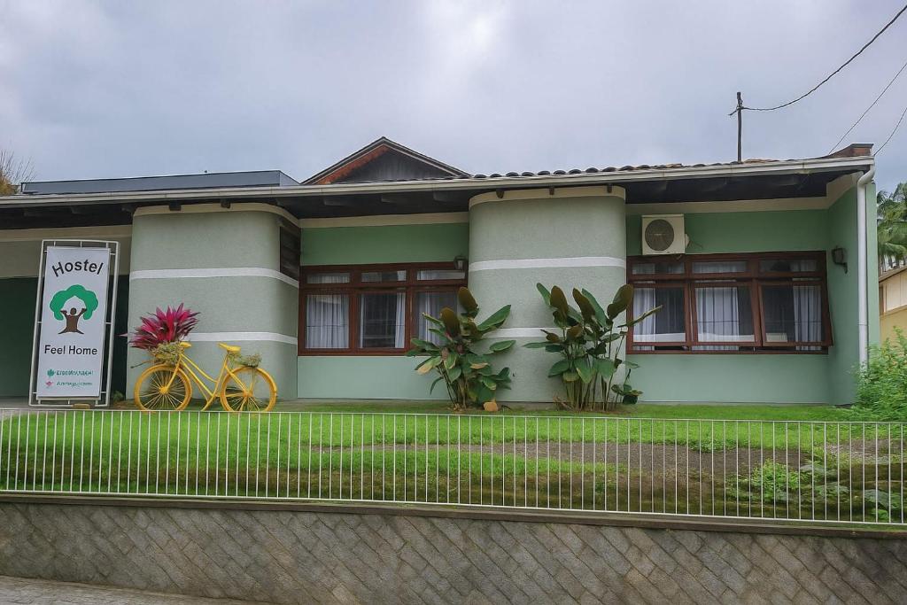 a house with two bikes parked in front of it at Hostel Feel Home in Blumenau