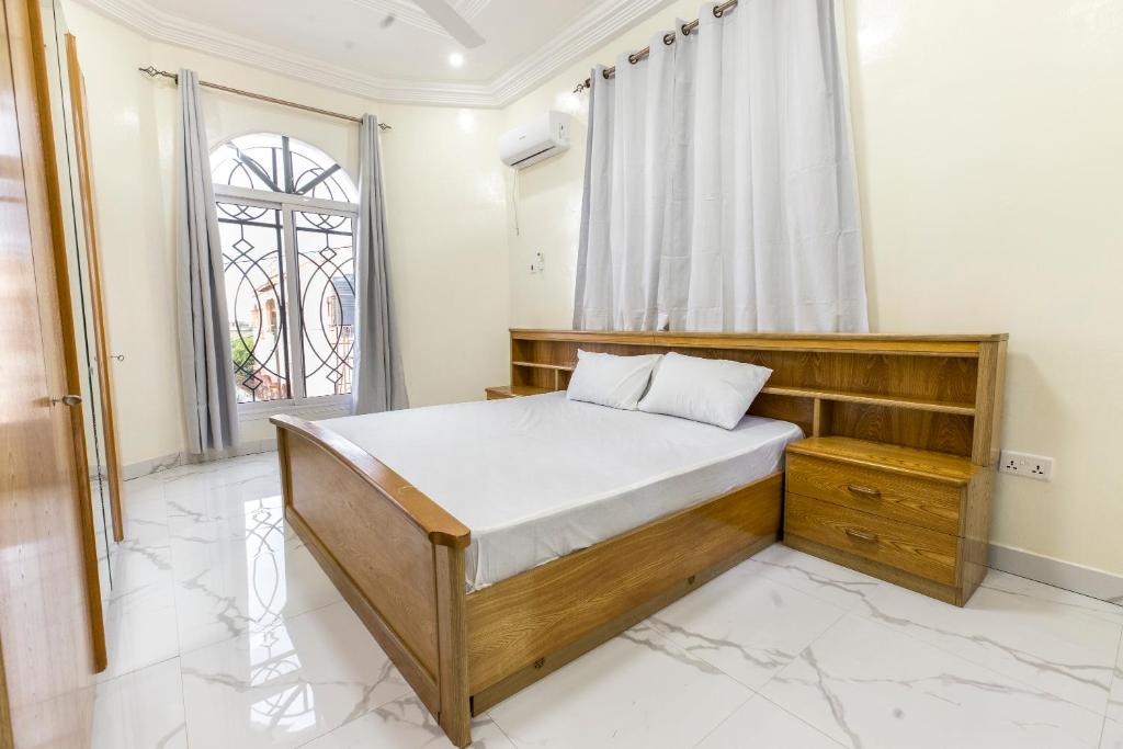 une chambre avec un lit et une fenêtre dans l'établissement Serenity Apartments, à Old Yundum