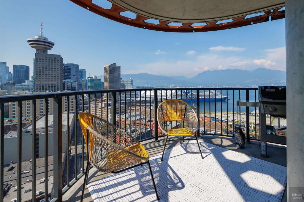 two chairs on a balcony with a view of the city at Spacious 2BD in Vancouver Patio with Ocean View in Vancouver