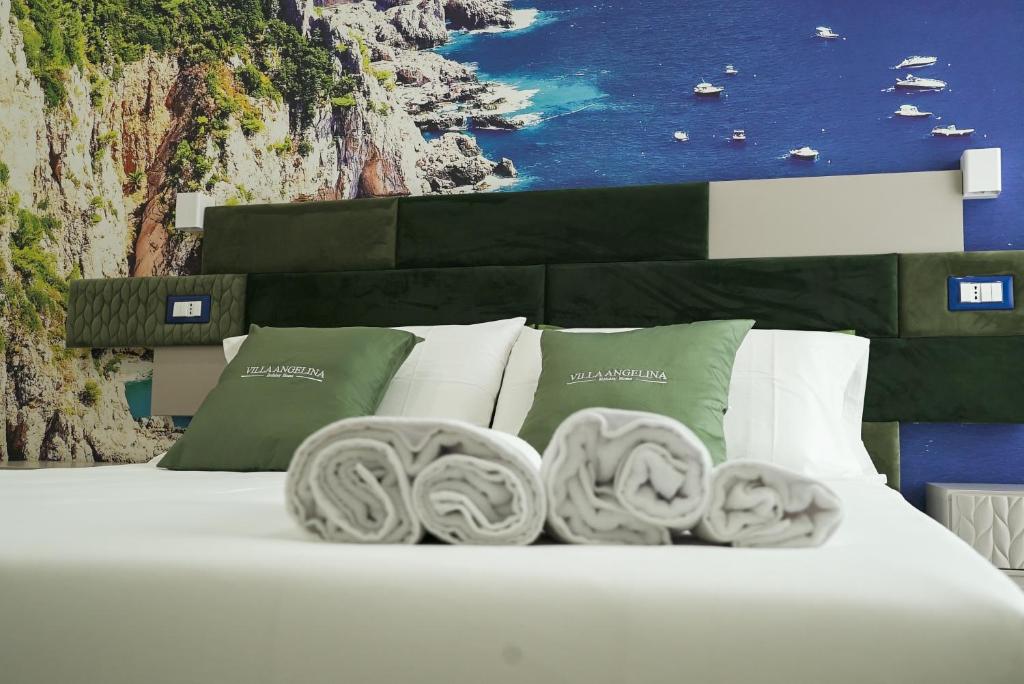 a bed with white pillows and a painting of the ocean at Villa Angelina in Pompei
