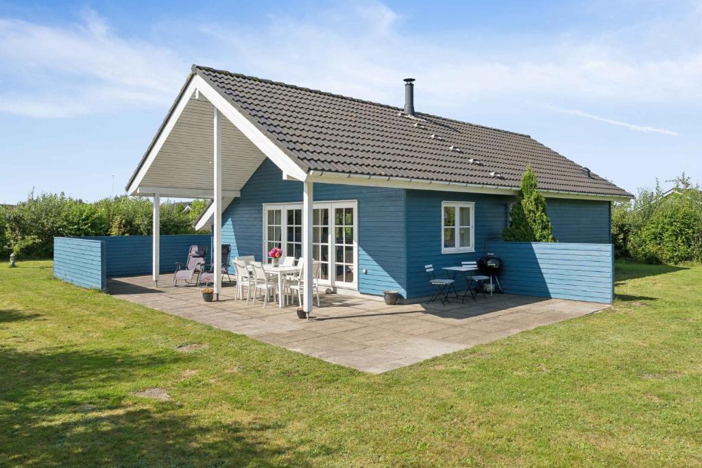 a blue house with a deck in a yard at Peaceful Cottage In Scenic Surroundings in Højsand