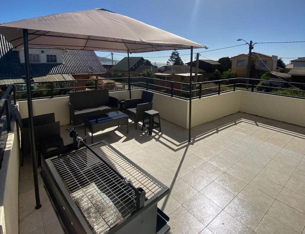 a patio with an umbrella on top of a roof at Hospedaje la machi in Algarrobo