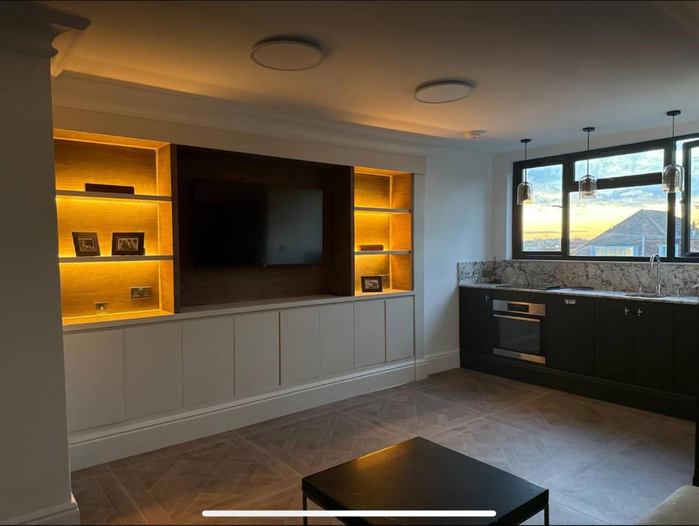 ein Wohnzimmer mit Fernseher und Theke in der Unterkunft The Brent Cross Penthouse in London