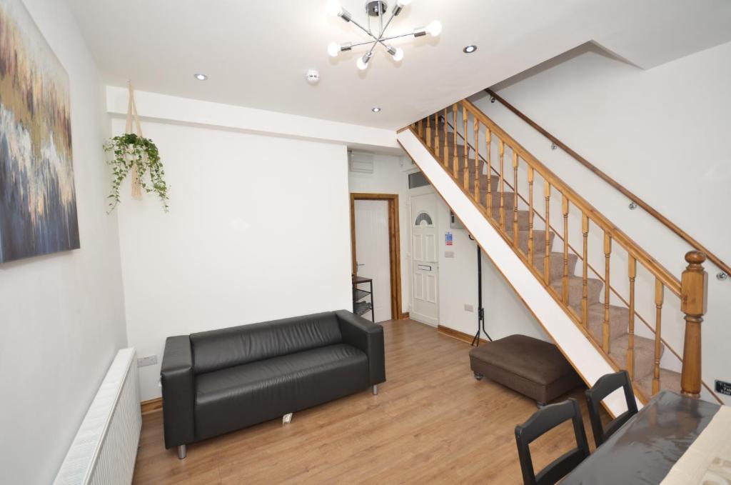 a living room with a couch and a staircase at JMG House - West Bromwich in West Bromwich