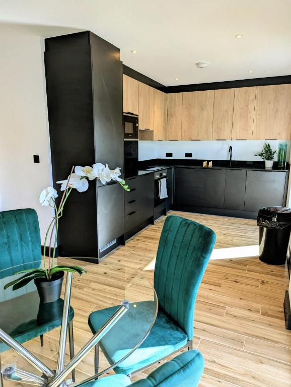 a kitchen with two chairs and a glass table at Elegant 2 bed flat with balcony in London in Finchley