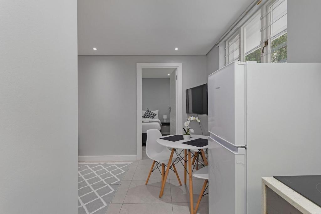 a kitchen with a white refrigerator and a table at Walk to Beach, Fast WiFi, Discounted, Nightlife in Kirstenhof