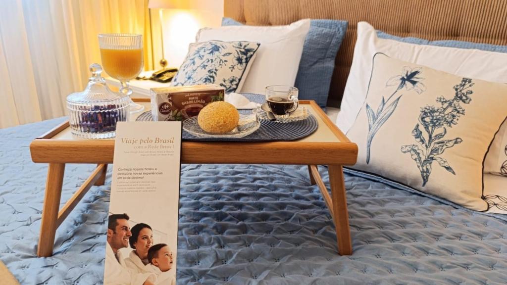 a tray of food on a table on a bed at GRU Airport Hotel - STAY HERE in Guarulhos