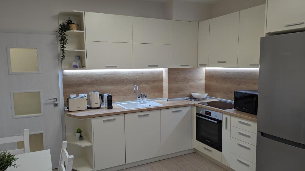 a kitchen with white cabinets and a sink at Well Equipped New Family Friendly One-Bedroom Flat in Sandanski