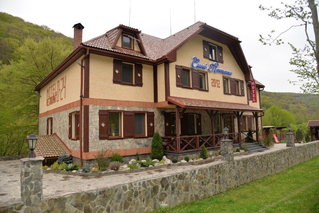 una casa grande en la parte superior de una pared de piedra en Syni Potoky, en Svalyava
