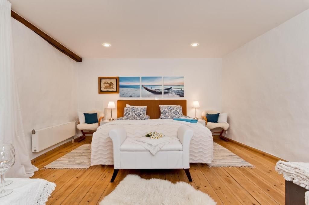 a bedroom with a white bed and a white chair at Old Town Central Apartment in Tallinn