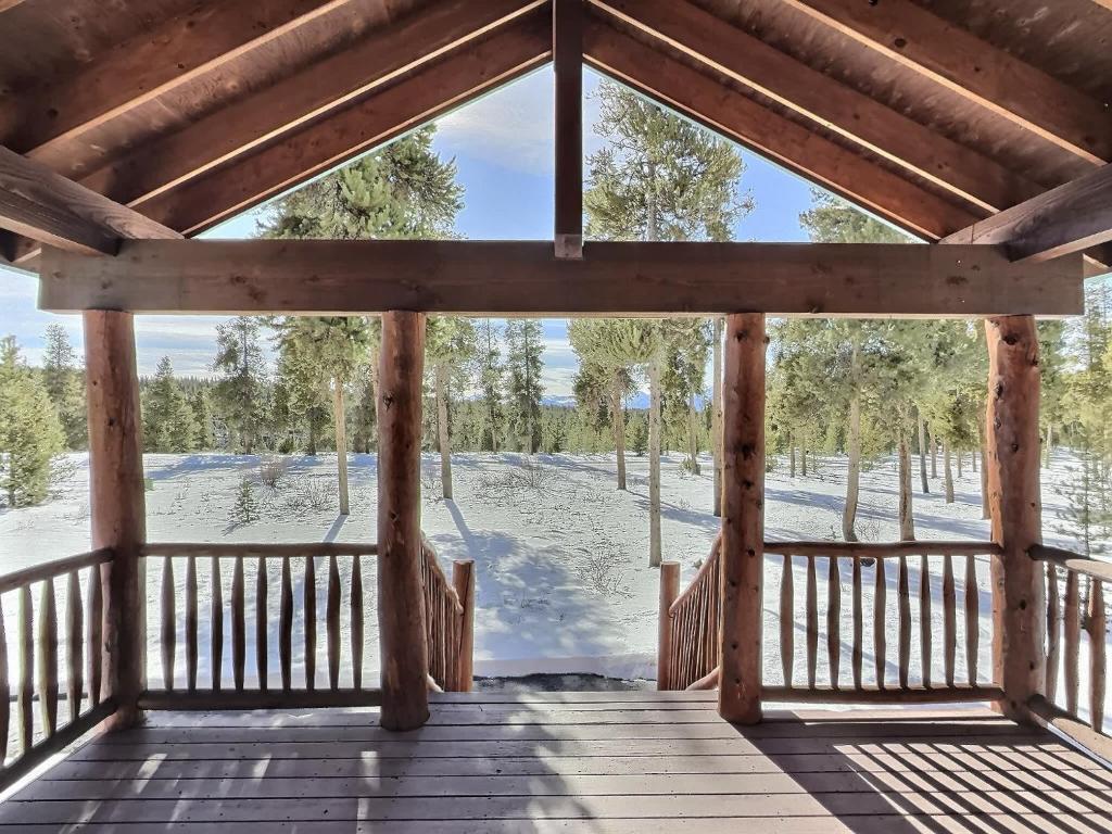 een houten veranda met uitzicht op een met sneeuw bedekt veld bij 2 Bed Cabin Fireplace Lodgepole Pines in Leadville
