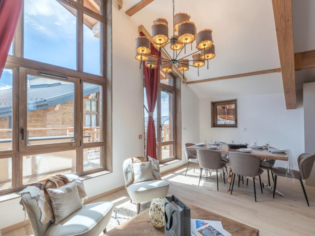 a dining room with a table and chairs and windows at Appartement moderne aux pieds des pistes, Alpe d'Huez - FR-1-645-92 in L'Alpe-d'Huez