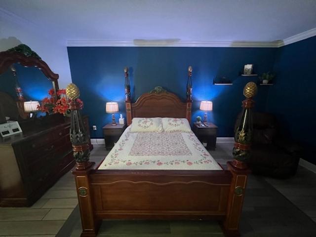 タンパにあるEl Palacioの青い壁のベッドルーム1室(木製ベッド1台付)