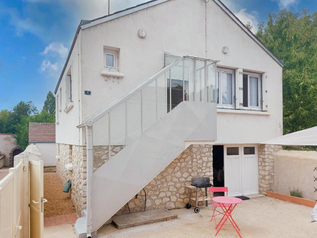 a white house with a staircase in front of it at Gîte Saint Lubin à Cloyes : Confort familial et charme régional - FR-1-581-157 in Cloyes-sur-le-Loir