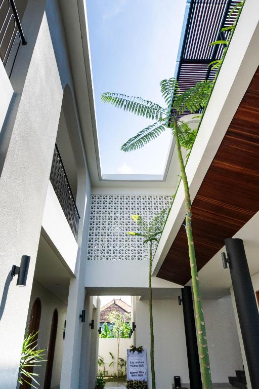 a palm tree in the middle of a building at Sascanaluna Padma Bali in Kesiman