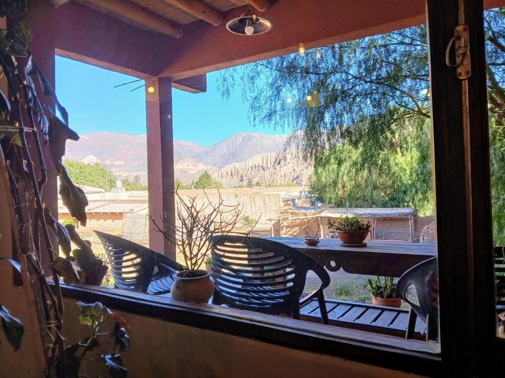 a table and chairs on a porch with a view of the mountains at Guasamayo in Tilcara