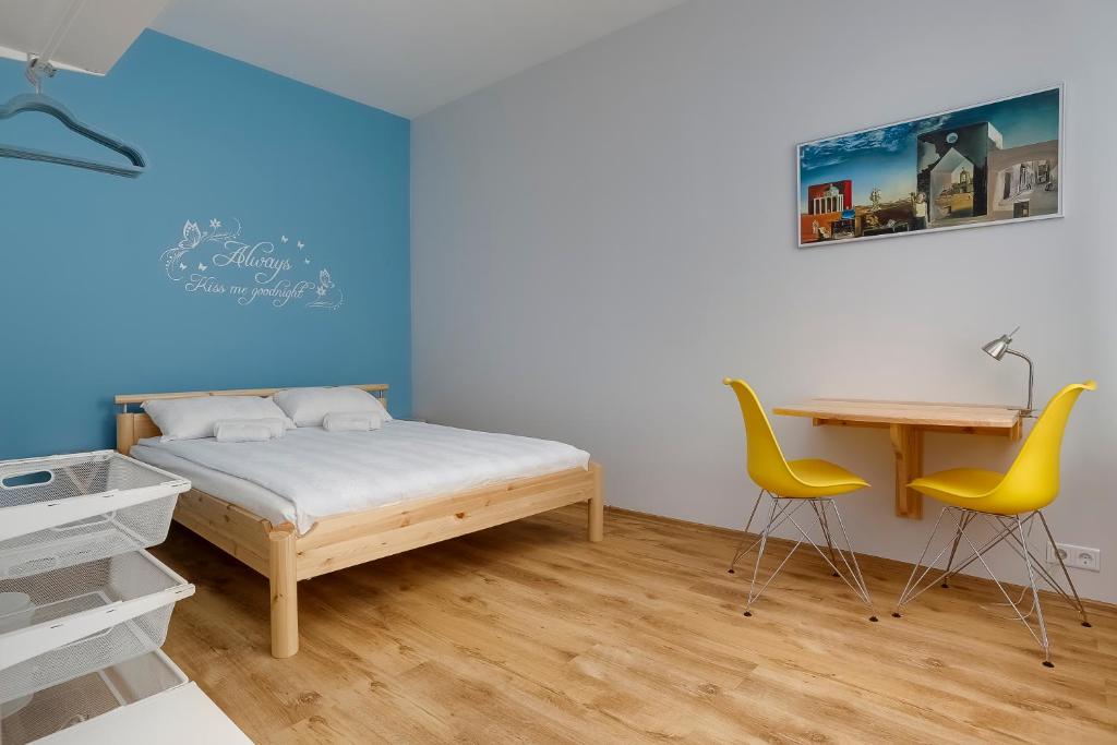 a bedroom with a bed and a desk and chairs at Orange Cat Rooms in Rīga