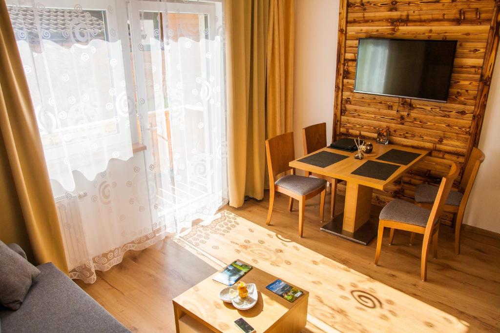 salon ze stołem i telewizorem w obiekcie Apartment Michael - Zell am See - Kaprun w mieście Piesendorf