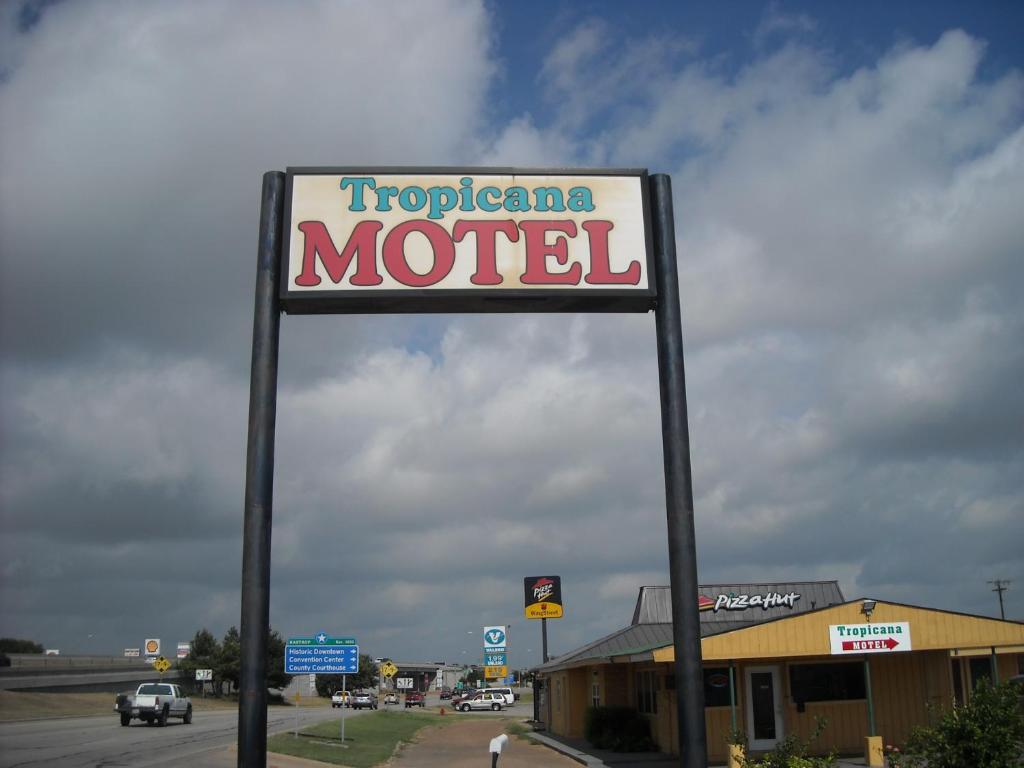 un panneau indiquant un motel devant un bâtiment dans l'établissement Tropicana Motel Bastrop, à Bastrop