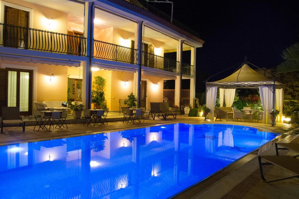 a swimming pool in front of a house at night at La Suite del Faro in Scalea