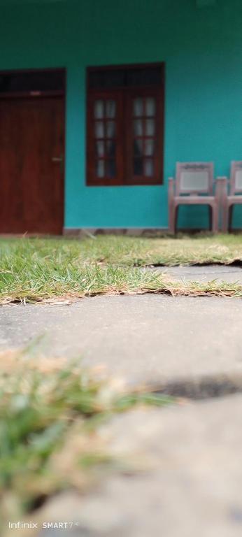a house with two chairs in front of a door at Dinu Homes Stay in Haputale