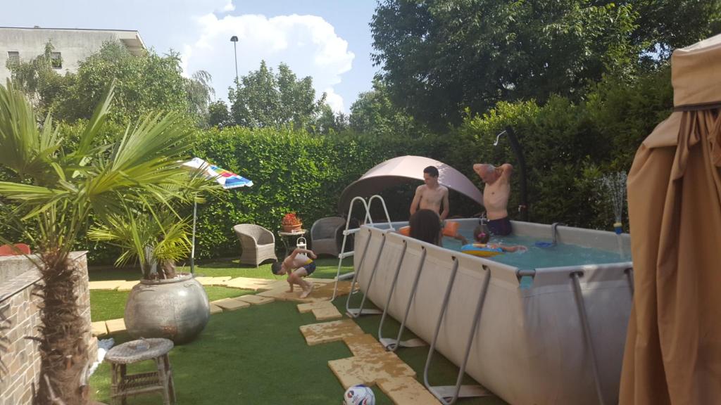 een groep mensen die rond een bubbelbad in een achtertuin staan bij B&B Ai Prati in Bergamo